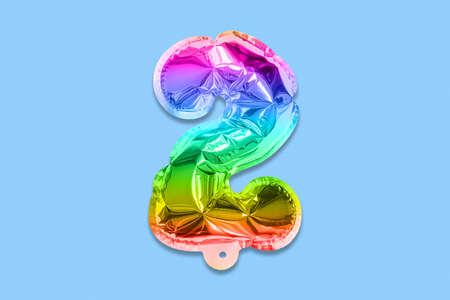 Rainbow foil balloon number, digit two on a blue background. Birthday greeting card with inscription 2. Top view. Numerical digit. Celebration event template.の写真素材