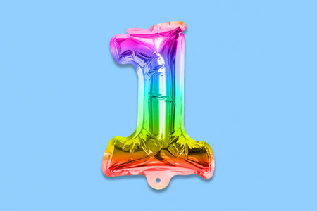 Rainbow foil balloon number, digit one on a blue background. Birthday greeting card with inscription 1. Top view. Numerical digit. Celebration event template.の写真素材