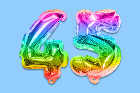 Rainbow foil balloon number, digit forty five on a blue background. Birthday greeting card with inscription 45. Anniversary concept. Numerical digit. Celebration event template.の写真素材
