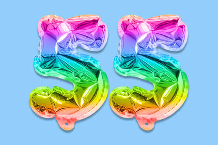 Rainbow foil balloon number, digit fifty five on a blue background. Birthday greeting card with inscription 55. Anniversary concept. Numerical digit. Celebration event template.の写真素材