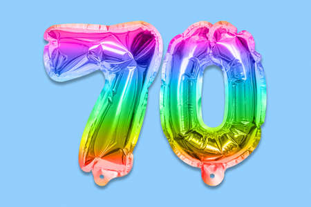 Rainbow foil balloon number, digit seventy on a blue background. Birthday greeting card with inscription 70. Anniversary concept. top view. Numerical digit. Celebration event template.の写真素材