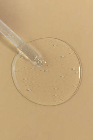 The texture of serum or oil with a pipette on a beige background. wellness and beauty concept.の写真素材
