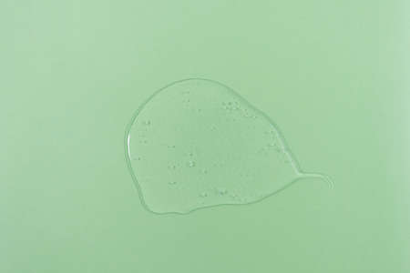 The texture of serum or oil on a green background. wellness and beauty concept.の写真素材