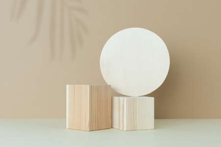 Wooden scenes with a shadow of tropical palm leaves on a light table against a beige wall background. Premium podium for advertising your product. Background for the product presentation.の写真素材