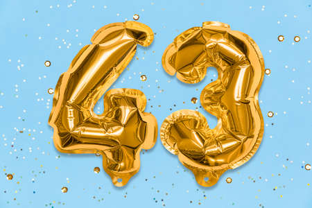 The number of the balloon made of golden foil, the number forty three on a blue background with sequins. Birthday greeting card with inscription 43. Numerical digit, Celebration event, template.の写真素材