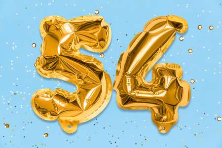 The number of the balloon made of golden foil, the number fifty-four on a blue background with sequins. Birthday greeting card with inscription 54. Numerical digit, Celebration event, template.の写真素材