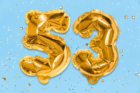 The number of the balloon made of golden foil, the number fifty-three on a blue background with sequins. Birthday greeting card with inscription 53. Numerical digit, Celebration event, template.の写真素材