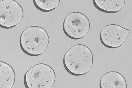 Drops of gel on a gray background. Serum or hyaluronic acid. The concept of cosmetics or virus protection.の写真素材