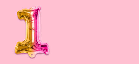 Rainbow foil balloon number, digit one on a pink background. Birthday greeting card with inscription 1. Top view. Numerical digit. Celebration event template. Banner.の写真素材
