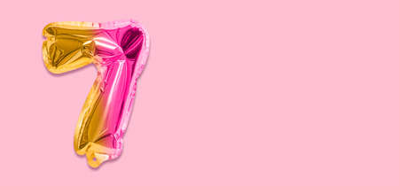 Rainbow foil balloon number, digit seven on a pink background. Birthday greeting card with inscription 7. Top view. Numerical digit. Celebration event template. Banner.の写真素材