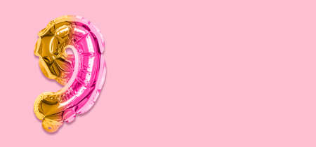 Rainbow foil balloon number, digit nine on a pink background. Birthday greeting card with inscription 9. Top view. Numerical digit. Celebration event template. Banner.の写真素材