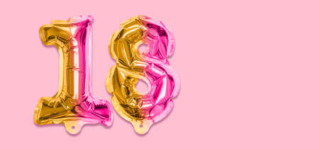 Rainbow foil balloon number, digit eighteen on a pink background. Birthday greeting card with inscription 18. Top view. Numerical digit. Celebration event template. Banner.の写真素材