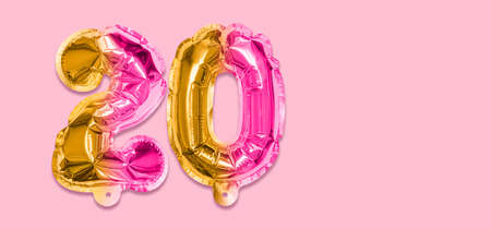 Rainbow foil balloon number, digit twenty on a pink background. Birthday greeting card with inscription 20. Anniversary concept. top view. Numerical digit. Celebration event template. Banner.の写真素材