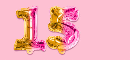 Rainbow foil balloon number, digit fifteen on a pink background. Birthday greeting card with inscription 15. Anniversary concept. top view. Numerical digit. Celebration event template. Banner.の写真素材