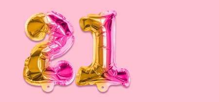 Rainbow foil balloon number, digit twenty one on a pink background. Birthday greeting card with inscription 21. Top view. Numerical digit. Celebration event template. Banner.の写真素材