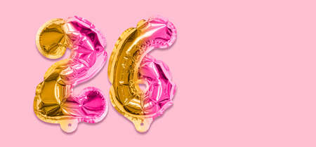Rainbow foil balloon number, digit twenty six on a pink background. Birthday greeting card with inscription 26. Top view. Numerical digit. Celebration event template. Banner.の写真素材