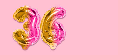 Rainbow foil balloon number, digit thirty six on a pink background. Birthday greeting card with inscription 36. Top view. Numerical digit. Celebration event template. Banner.の写真素材