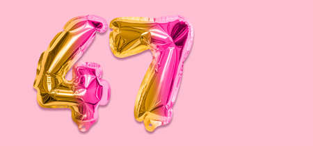 Rainbow foil balloon number, digit forty seven on a pink background. Birthday greeting card with inscription 47. Top view. Numerical digit. Celebration event template. Banner.の写真素材
