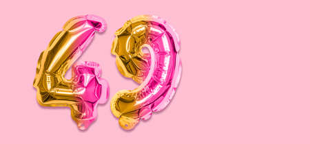 Rainbow foil balloon number, digit forty nine on a pink background. Birthday greeting card with inscription 49. Top view. Numerical digit. Celebration event template. Banner.の写真素材