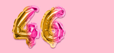 Rainbow foil balloon number, digit forty six on a pink background. Birthday greeting card with inscription 46. Top view. Numerical digit. Celebration event template. Banner.の写真素材