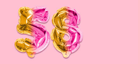 Rainbow foil balloon number, digit fifty eight on a pink background. Birthday greeting card with inscription 58. Top view. Numerical digit. Celebration event template. Banner.の写真素材