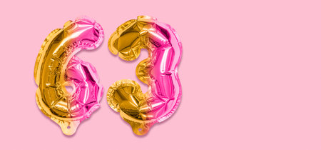Rainbow foil balloon number, digit sixty three on a pink background. Birthday greeting card with inscription 63. Top view. Numerical digit. Celebration event template. Banner.の写真素材