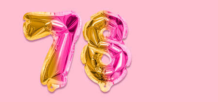Rainbow foil balloon number, digit seventy eight on a pink background. Birthday greeting card with inscription 78. Top view. Numerical digit. Celebration event template. Banner.の写真素材