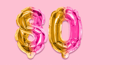Rainbow foil balloon number, digit eighty on a pink background. Birthday greeting card with inscription 80. Anniversary concept. top view. Numerical digit. Celebration event template. Banner.の写真素材