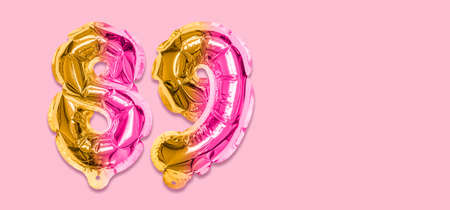 Rainbow foil balloon number, digit eighty nine on a pink background. Birthday greeting card with inscription 89. Top view. Numerical digit. Celebration event template. Banner.の写真素材