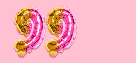 Rainbow foil balloon number, digit ninety nine on a pink background. Birthday greeting card with inscription 99. Top view. Numerical digit. Celebration event template. Banner.の写真素材