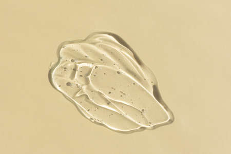 Transparent hyaluronic gel or serum on a beige background. Smear of skincare cosmetics product. wellness and beauty concept. top view.の写真素材
