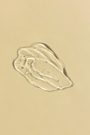 Transparent hyaluronic gel or serum on a beige background. Smear of skincare cosmetics product. wellness and beauty concept. top view.の写真素材