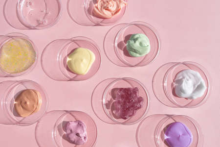 The texture of serum, oil, hyaluronic acid or gel on a pink background. A drop of yellow cosmetic product. wellness and beauty concept.の写真素材
