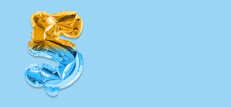 Rainbow foil balloon number, digit five on a blue background. Birthday greeting card with inscription 5. Anniversary concept. top view. Numerical digit. Celebration event template. Banner.の写真素材