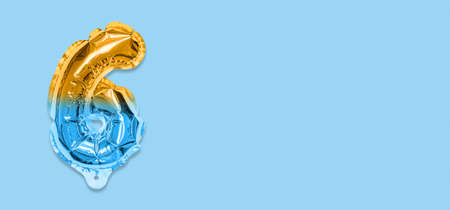 Rainbow foil balloon number, digit six on a blue background. Birthday greeting card with inscription 6. Top view. Numerical digit. Celebration event template. Banner.の写真素材
