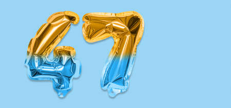 Rainbow foil balloon number, digit forty seven on a blue background. Birthday greeting card with inscription 47. Top view. Numerical digit. Celebration event template. Bannerの写真素材