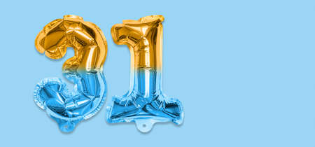 Rainbow foil balloon number, digit thirty one on a blue background. Birthday greeting card with inscription 31. Top view. Numerical digit. Celebration event template. Bannerの写真素材