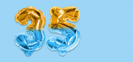Rainbow foil balloon number, digit thirty five on a blue background. Birthday greeting card with inscription 35. Anniversary concept. Numerical digit. Celebration event template. Bannerの写真素材