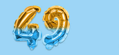 Rainbow foil balloon number, digit forty nine on a blue background. Birthday greeting card with inscription 49. Top view. Numerical digit. Celebration event template. Bannerの写真素材
