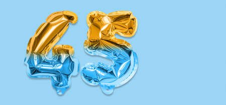Rainbow foil balloon number, digit forty five on a blue background. Birthday greeting card with inscription 45. Anniversary concept. Numerical digit. Celebration event template. Bannerの写真素材
