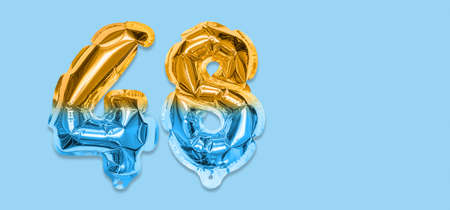 Rainbow foil balloon number, digit forty eight on a blue background. Birthday greeting card with inscription 48. Top view. Numerical digit. Celebration event template. Bannerの写真素材