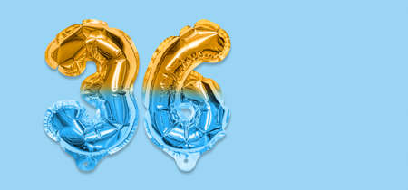 Rainbow foil balloon number, digit thirty six on a blue background. Birthday greeting card with inscription 36. Top view. Numerical digit. Celebration event template. Bannerの写真素材