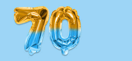 Rainbow foil balloon number, digit seventy on a blue background. Birthday greeting card with inscription 70. Anniversary concept. top view. Numerical digit. Celebration event template. Bannerの写真素材