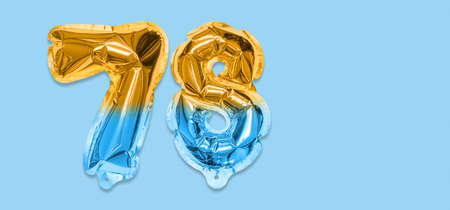 Rainbow foil balloon number, digit seventy eight on a blue background. Birthday greeting card with inscription 78. Top view. Numerical digit. Celebration event template. Bannerの写真素材
