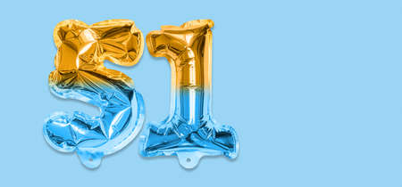 Rainbow foil balloon number, digit fifty one on a blue background. Birthday greeting card with inscription 51. Top view. Numerical digit. Celebration event template. Bannerの写真素材