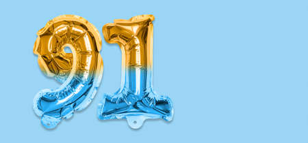 Rainbow foil balloon number, digit ninety one on a blue background. Birthday greeting card with inscription 91. Top view. Numerical digit. Celebration event template. Bannerの写真素材
