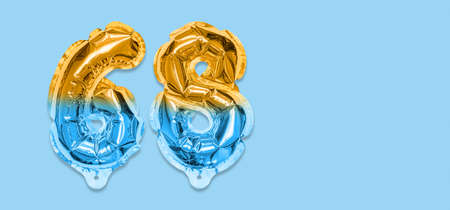 Rainbow foil balloon number, digit sixty eight on a blue background. Birthday greeting card with inscription 68. Top view. Numerical digit. Celebration event template. Bannerの写真素材