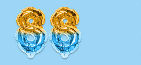 Rainbow foil balloon number, digit eighty eight on a blue background. Birthday greeting card with inscription 88. Top view. Numerical digit. Celebration event template. Bannerの写真素材
