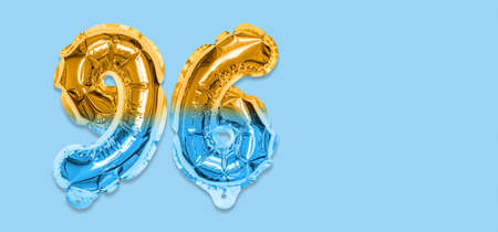 Rainbow foil balloon number, digit ninety six on a blue background. Birthday greeting card with inscription 96. Top view. Numerical digit. Celebration event template. Bannerの写真素材