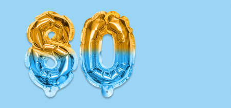 Rainbow foil balloon number, digit eighty on a blue background. Birthday greeting card with inscription 80. Anniversary concept. top view. Numerical digit. Celebration event template. Bannerの写真素材